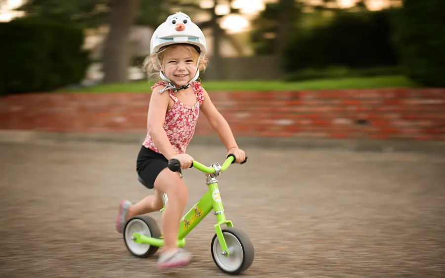 Unser Laufrad-Kaufguide: Mädchen mit Helm auf dem Laufrad
